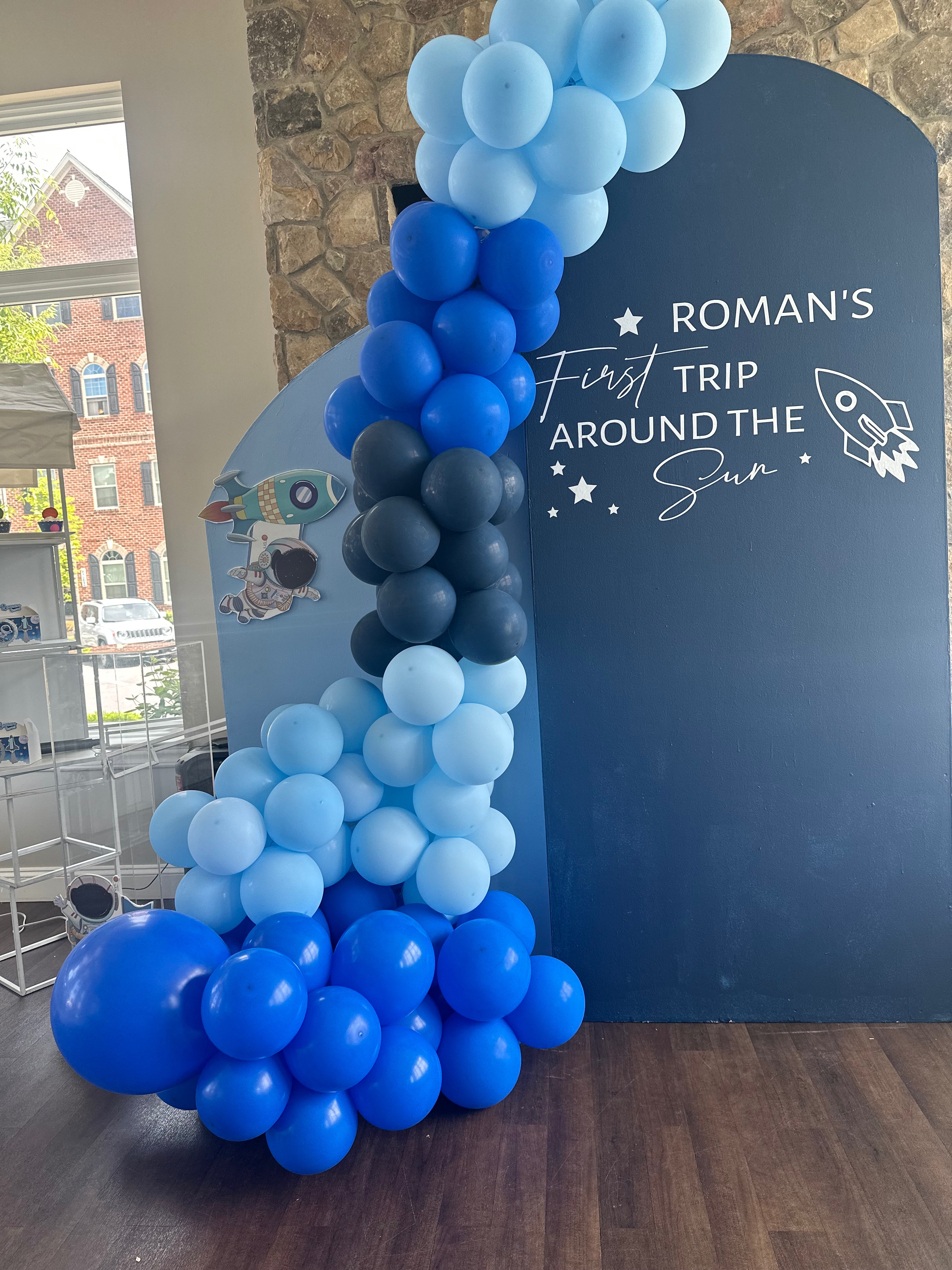 Blue balloon garland and rocket themed backdrop